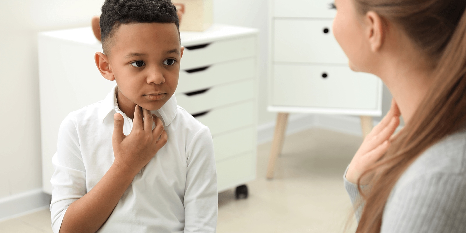 Image of a speech and language instructor helping a young child with vocalization 